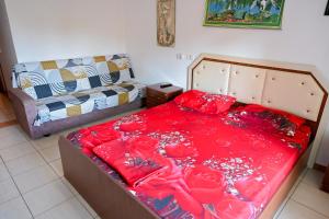a bedroom with a bed covered in red sheets at Gini Palace - Shengjin in Shëngjin