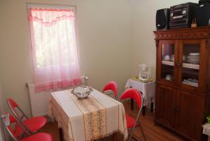 バダチョニトマイにあるKincsem Apartmanの赤い椅子とテーブル、キャビネットが備わる客室です。