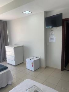 a room with a tv and a chest of drawers at Ribeiro Flat in Araxá