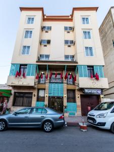 ein Gebäude mit zwei davor geparkt in der Unterkunft Hotel Akouas in Meknès