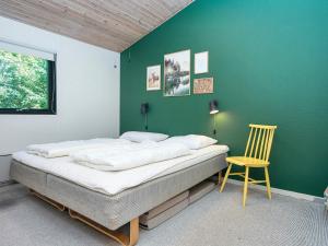 1 dormitorio con una pared verde, 1 cama y 1 silla en 6 person holiday home in Glesborg-By Traum, en Glesborg