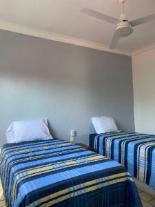 two beds in a room with blue walls at Depa BN 06 in Barra de Navidad +2 photos