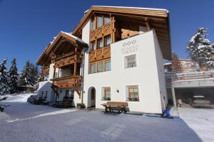 een gebouw met een bank ervoor bij Residence Vajolet San Cassiano in San Cassiano