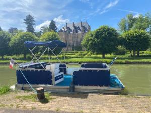 a boat on the water with a building in the background at Séjour insolite en bateau sur le canal à Châtillon-en-Bazois, 8 personnes - API-1-46-25 in Châtillon-en-Bazois