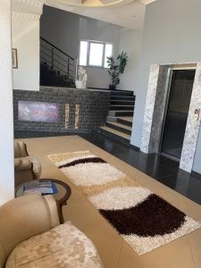 a living room with rugs on the floor and stairs at Hotel Albatros in Prizren