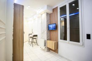 een kamer met een tv aan een muur naast een raam bij Appartement Royal carré d'or de Paris 17 eme in Parijs