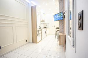 een hal met een witte tegelvloer en een keuken bij Appartement Royal carré d'or de Paris 17 eme in Parijs +4 foto's