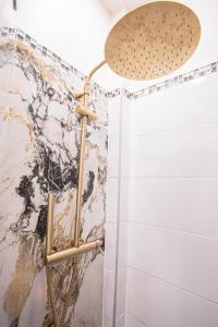 een douche met een douchekop in een badkamer bij Appartement Royal carré d'or de Paris 17 eme in Parijs