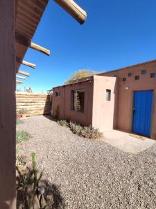 a building with a blue door on the side of it at Villarica Atacama - Antigua Cabanas Rica Rica in San Pedro de Atacama