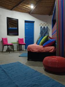 a room with a bed and two chairs and a table at Villarica Atacama - Antigua Cabanas Rica Rica in San Pedro de Atacama