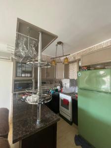 eine Küche mit einer Theke und einem grünen Kühlschrank in der Unterkunft Blumar Eldome in Ain Suchna