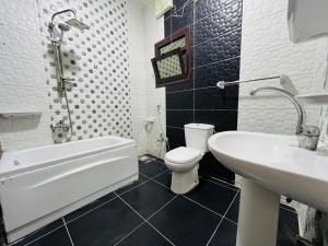 a bathroom with a white toilet and a sink at شقة فندقية vip برج رئيسي شارع الغشام مع موقف المنصورة in Manshīyat as Sādāt