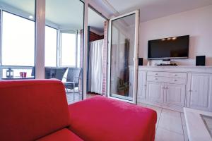 a living room with a red couch and a tv at Haus Horizont HZ09 in Cuxhaven