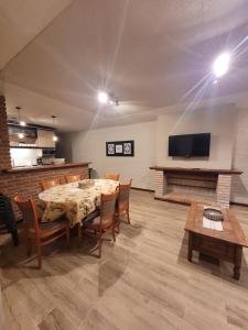 a dining room with a table and chairs and a television at Casa en calle Mondello, Piriápolis in Piriápolis