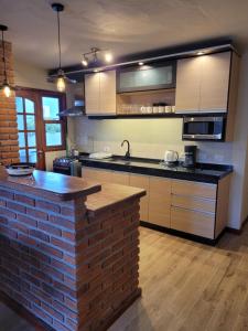 a kitchen with a brick counter and a brick wall at Casa en calle Mondello, Piriápolis in Piriápolis