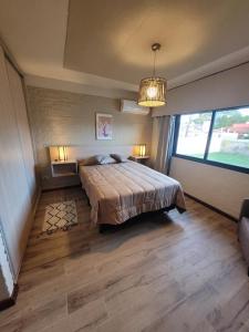 a bedroom with a bed and a large window at Casa en calle Mondello, Piriápolis in Piriápolis