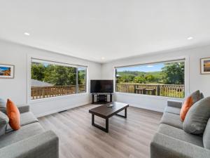 a living room with two couches and a flat screen tv at Fantail Haven in Kinloch