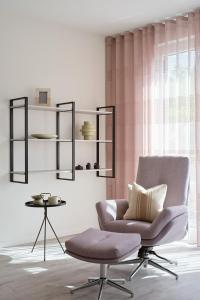 un salon avec une chaise et une table dans l'établissement Apartment B14 mit Südbalkon & Nutzung der Wellness- & Aktivbereiche im "Pine Hill Resort", à Zirchow