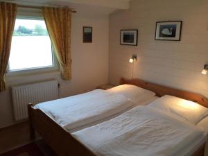 Postel nebo postele na pokoji v ubytování Ferienhaus direkt am Binnensee mit eigenem Steg