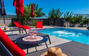 a pool with a table with two glasses and chairs at Villa Casa Grigia in Zadar