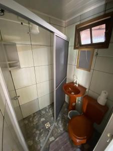 a small bathroom with a toilet and a shower at Pousada Margareth in Ilha do Mel