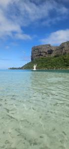 a body of water with a mountain in the background at Taria Camping in Te-Fare-Arii
