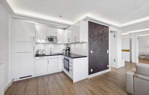 an open kitchen with white cabinets and a couch at Cloud in Binz