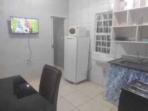 a kitchen with a refrigerator and a table and a sink at Apto 10 preço acessível in Brasília