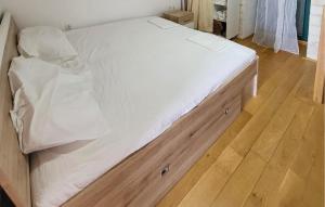 a large white bed in a room with a wooden floor at 1 Bedroom Nice Home In Tisno in Tisno