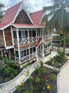a house with a red roof and a garden at Caye Caulker Boutique Guesthouse in Caye Caulker