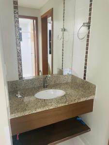 a bathroom counter with a sink and a mirror at Hotel boulevard caldas novas in Caldas Novas