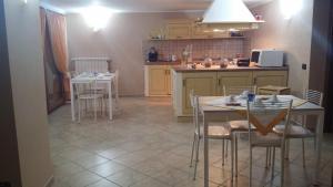 uma cozinha com duas mesas e cadeiras e um balcão em Alba Chiara em Anzio