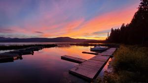a sunset on a lake with a dock and a boat at Jared's Wild Rose Ranch Resort in Lake