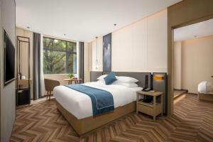 a large bedroom with a large bed and a desk at Mehood Lestie, Pingxiang Bus Station Food Street in Pingxiang