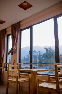 Una habitación con una mesa y sillas y una ventana grande. en Sapa indigo inn, en Sa Pa