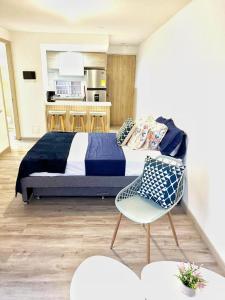 a bedroom with a large bed and a chair at Apartaestudio en Santa Marta 308 in Gaira