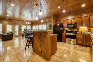a large kitchen with wooden cabinets and a kitchen island at Mountain Charm- Hot Tub, Game Room, Theater Room, free Attraction Tickets!!! in Sevierville
