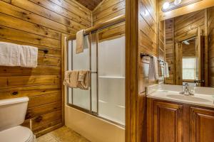 a bathroom with a shower and a toilet and a sink at Mountain Charm- Hot Tub, Game Room, Theater Room, free Attraction Tickets!!! in Sevierville +57 photos