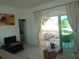 a living room with a sliding glass door to a patio at Apartamento 150m da praia de Canoa Quebrada in Canoa Quebrada