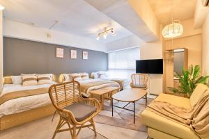 a bedroom with two beds and a table and chairs at Shinjuku Waseda Sky in Tokyo