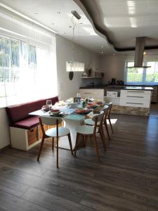 a dining room with a table and chairs in a kitchen at Ferienwohnung Dorfleben - 4 Schlafzimmer für Familien & Teams in Windisch Minihof +44 photos