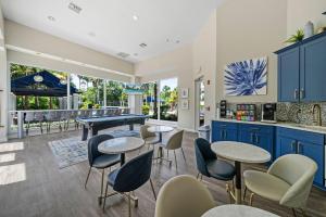 a kitchen with blue cabinets and tables and chairs at Stylish 2br2ba W Pool, Gym Near Airport #3 in Tampa