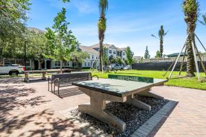 a picnic table and benches in a park with palm trees at Stylish 2br2ba W Pool, Gym Near Airport #3 in Tampa