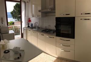 a kitchen with white cabinets and a stove top oven at Ranco Villa Lina in Ranco
