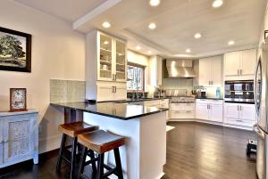 a large kitchen with white cabinets and a large island at Beartopia- Hot Tub, Views, 2 Primary Suites! in Killington