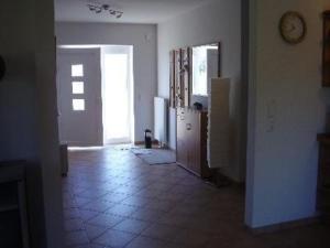 une pièce avec une cuisine et un couloir avec une horloge dans l'établissement Bungalow Meeresbrise mit WLAN, à Butjadingen 3 autres photos