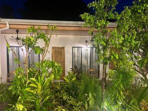 a small white house with plants in front of it at Infinity Beach Dhigurah in Dhigurah