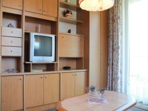 ein Wohnzimmer mit einem TV und einem Tisch in der Unterkunft Haus Bärnthaler in Faak am See