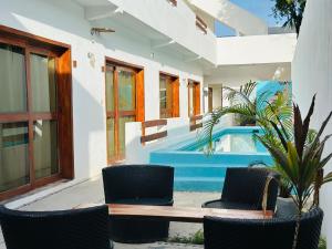a patio with chairs and a table and a pool at Casa Coral Pueblito - Self Check In in Mahahual