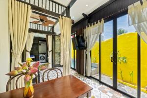 une salle à manger avec une table et une grande fenêtre dans l'établissement Rosie Countryside villa- 1BR retreat, à Hiếu Nhơn